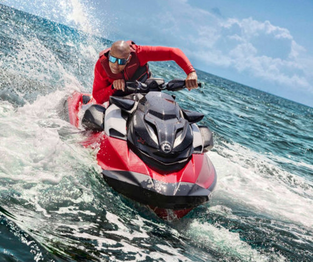 Alquiler por libre de moto de agua en Ibiza Hombre derrapando con su moto de agua Sea-Doo en el mar frente a la costa de Ibiza.